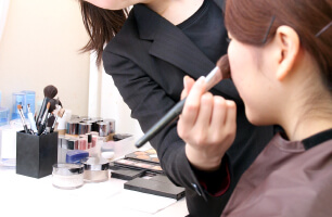 花嫁がプロのスタイリストにウェディングヘアメイクを施されている様子