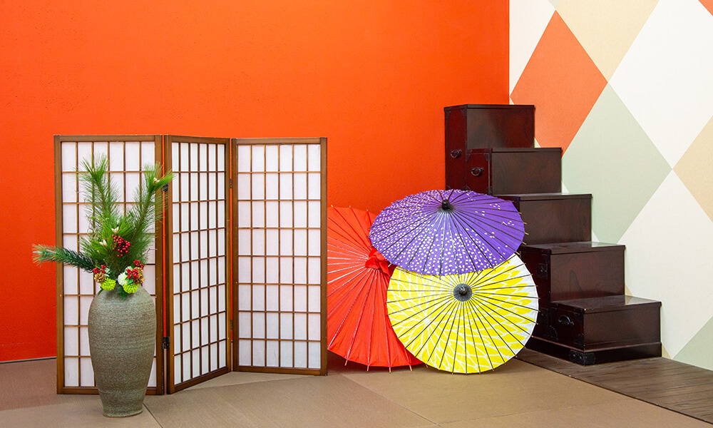 赤い壁に和傘や生け花を配置した和の風情あふれる「マイブライド尾張旭」のスタジオイメージ
