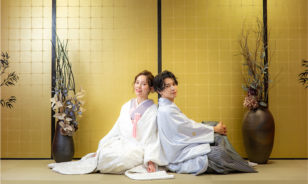 金屏風をバックにし、和をテーマにした「マイブライド天白」のスタジオで和装フォトを撮影する花嫁と新郎のイメージ