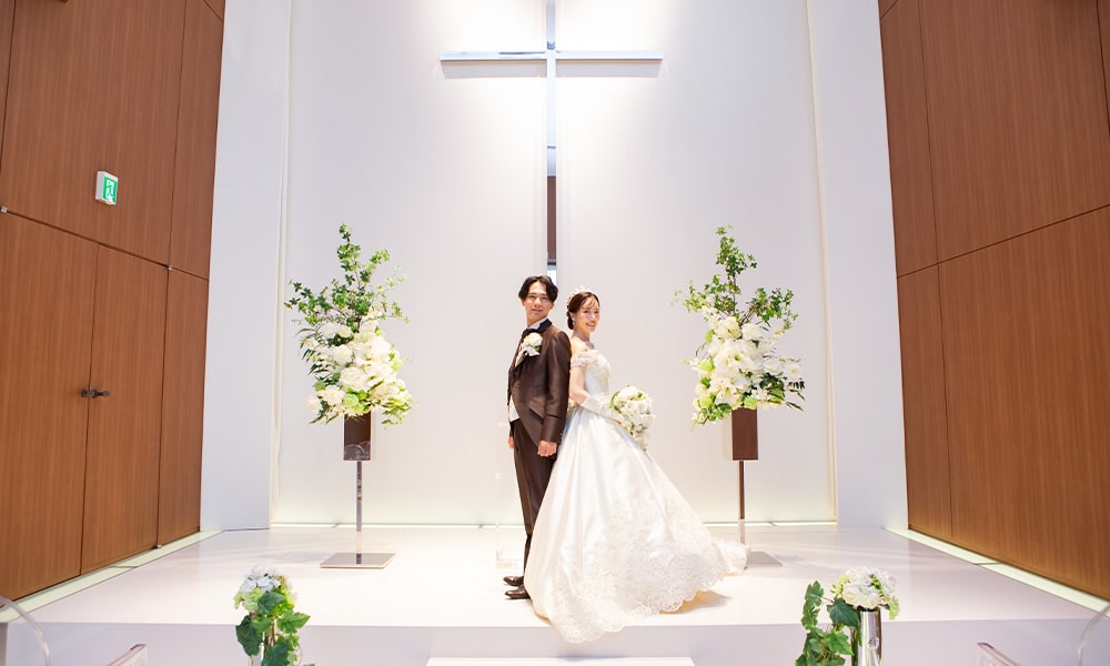 純白の「マイブライド津」のチャペルで洋装フォトを撮影する花嫁と新郎のイメージ